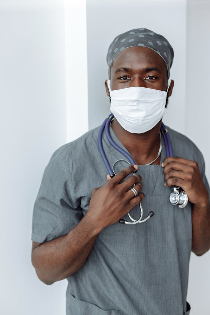 services-02 Portrait of a healthcare worker wearing a face mask and scrubs, demonstrating COVID-19 safety measures.